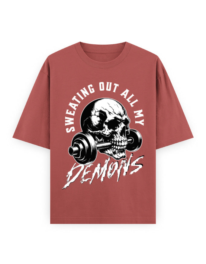 Red t-shirt with skull and barbell graphic and text 'Sweating Out All My Demons' on a white background