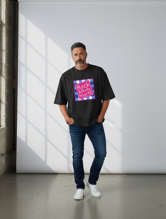 Frolic Saga black oversized 100% cotton t-shirt with a parody graphic that reads "Back & Body Hurts" in a pink box with a blue and white checkered background.