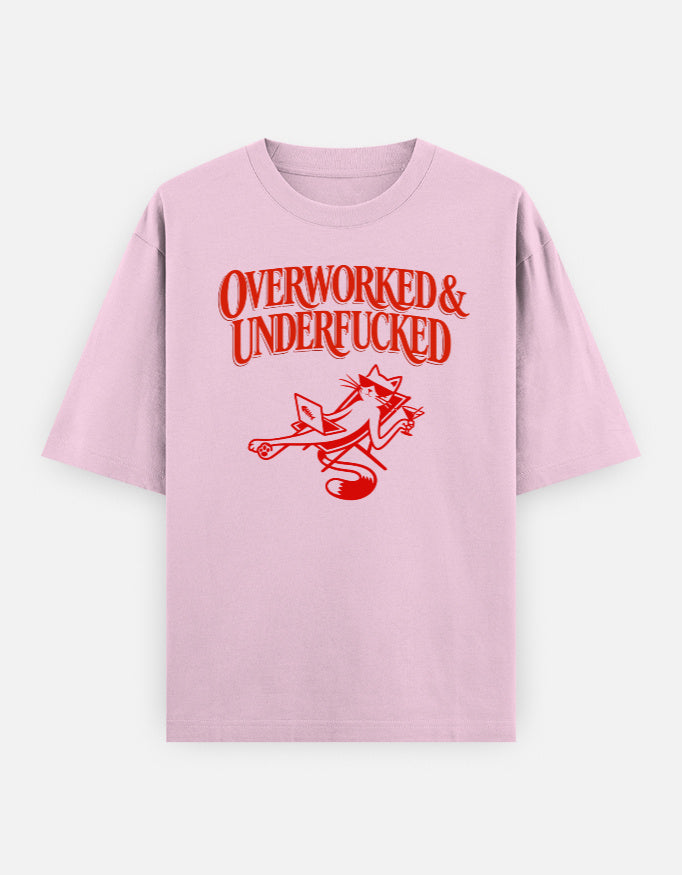 Pink t-shirt with red text 'OVERWORKED & UNDERFUCKED' and graphic on a white background