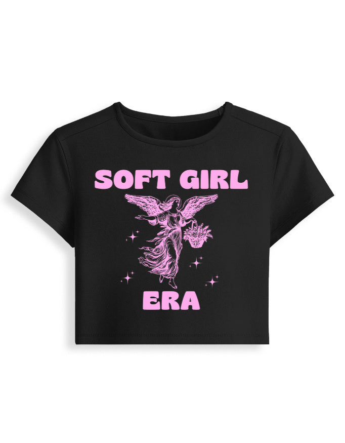 Black t-shirt with pink 'SOFT GIRL ERA' text and angel graphic on a white background