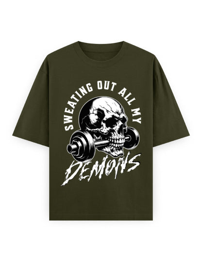 Green t-shirt with skull and barbell graphic and text 'Sweating Out All My Demons' on a white background