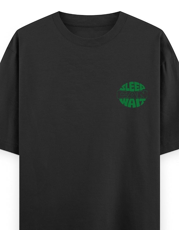 Frolic Saga black 100% cotton oversized t-shirt with green circular 'Sleep Can Wait' graphic on chest.