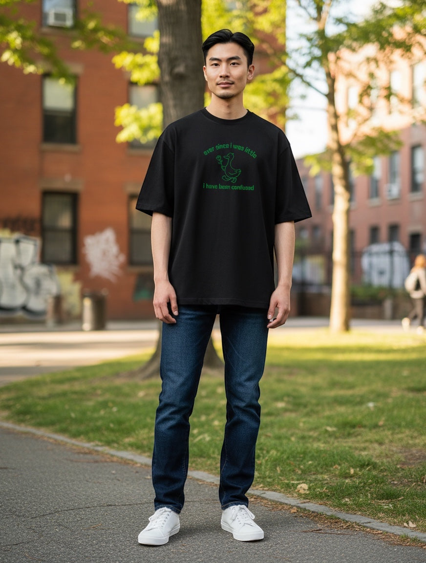 Frolic Saga black oversized cotton t-shirt with green duck graphic and text "ever since i was little i have been confused."