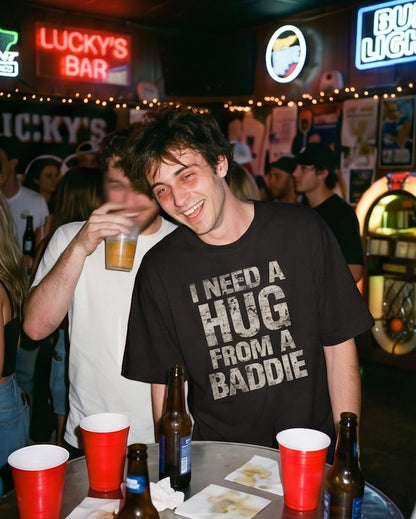 Frolic Saga black 100% cotton oversized t-shirt with distressed "I Need A Hug From A Baddie" slogan.