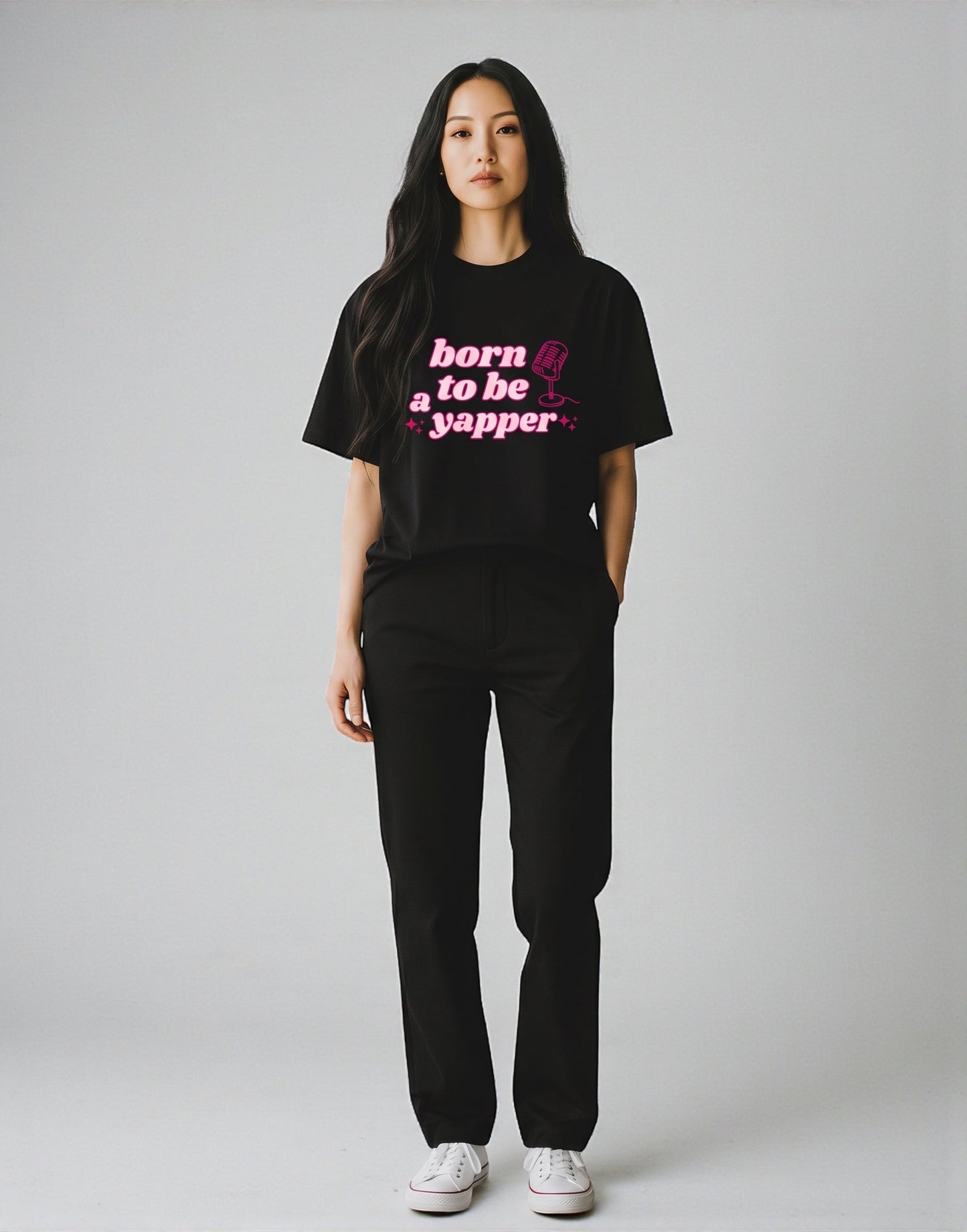 Frolic Saga black 100% cotton oversized t-shirt with pink "born to be a yapper" graphic and microphone icon.