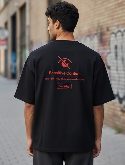 Frolic Saga black 100% cotton oversized t-shirt with red 'Sensitive Content' graphic and 'See Why' button on back.
