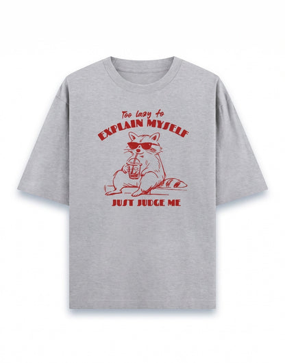 Frolic Saga grey 100% cotton oversized t-shirt with a red graphic of a raccoon wearing sunglasses and holding a drink, text reads "Too lazy to explain myself, JUST JUDGE ME."