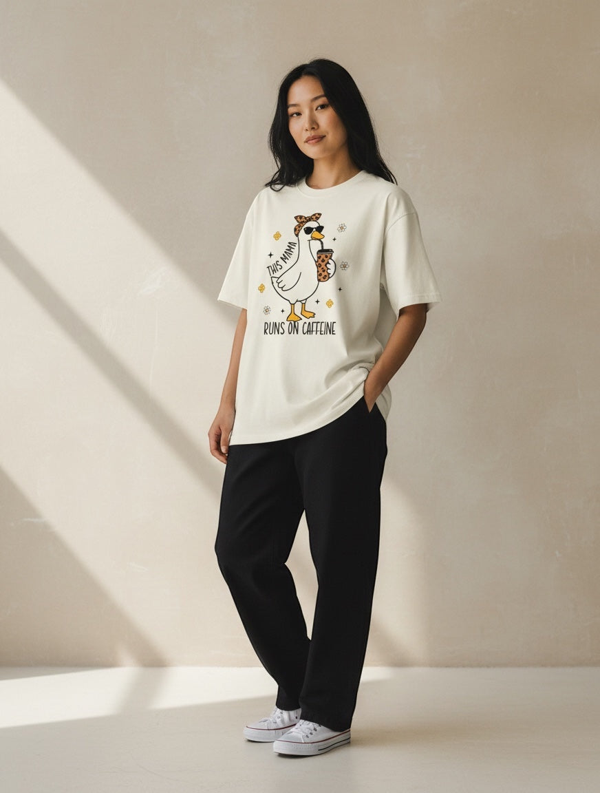 Frolic Saga cream 100% cotton oversized t-shirt with a graphic of a duck wearing sunglasses and holding a coffee cup, text reads "This mama runs on caffeine".