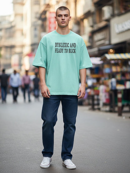 Frolic Saga unisex oversized mint green 100% cotton t-shirt with black text graphic on chest.