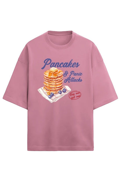 Frolic Saga oversized pink French terry t-shirt with a graphic print of pancakes and blueberries, reading "Pancakes & Panic Attacks".