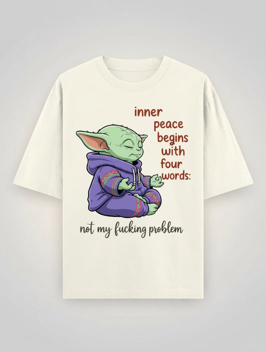Frolic Saga cream 100% cotton oversized t-shirt with a graphic of Yoda meditating, wearing a purple hoodie, with text "inner peace begins with four words: not my fucking problem".