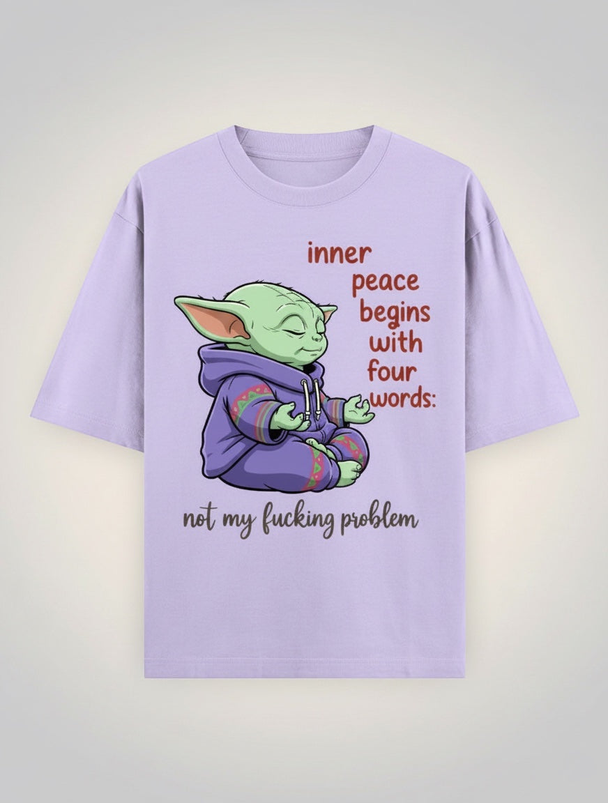 Frolic Saga unisex oversized lavender 100% cotton t-shirt with a graphic of Grogu meditating, wearing a purple hoodie, with text "inner peace begins with four words: not my fucking problem".