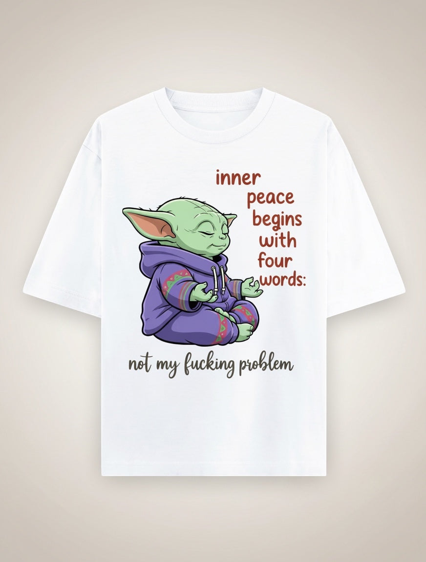 Frolic Saga white 100% cotton oversized t-shirt with a graphic of a green character meditating, wearing a purple hoodie. Text reads "inner peace begins with four words: not my fucking problem."