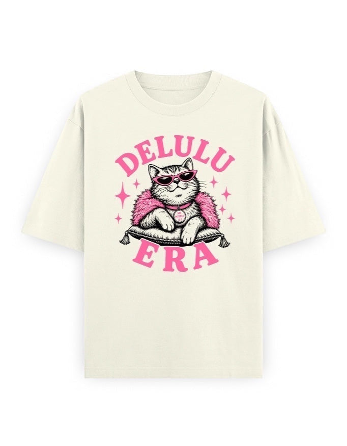 Frolic Saga Unisex oversized classic t-shirt in cream, 100% cotton, featuring a graphic of a cat wearing sunglasses and a pink fluffy boa.