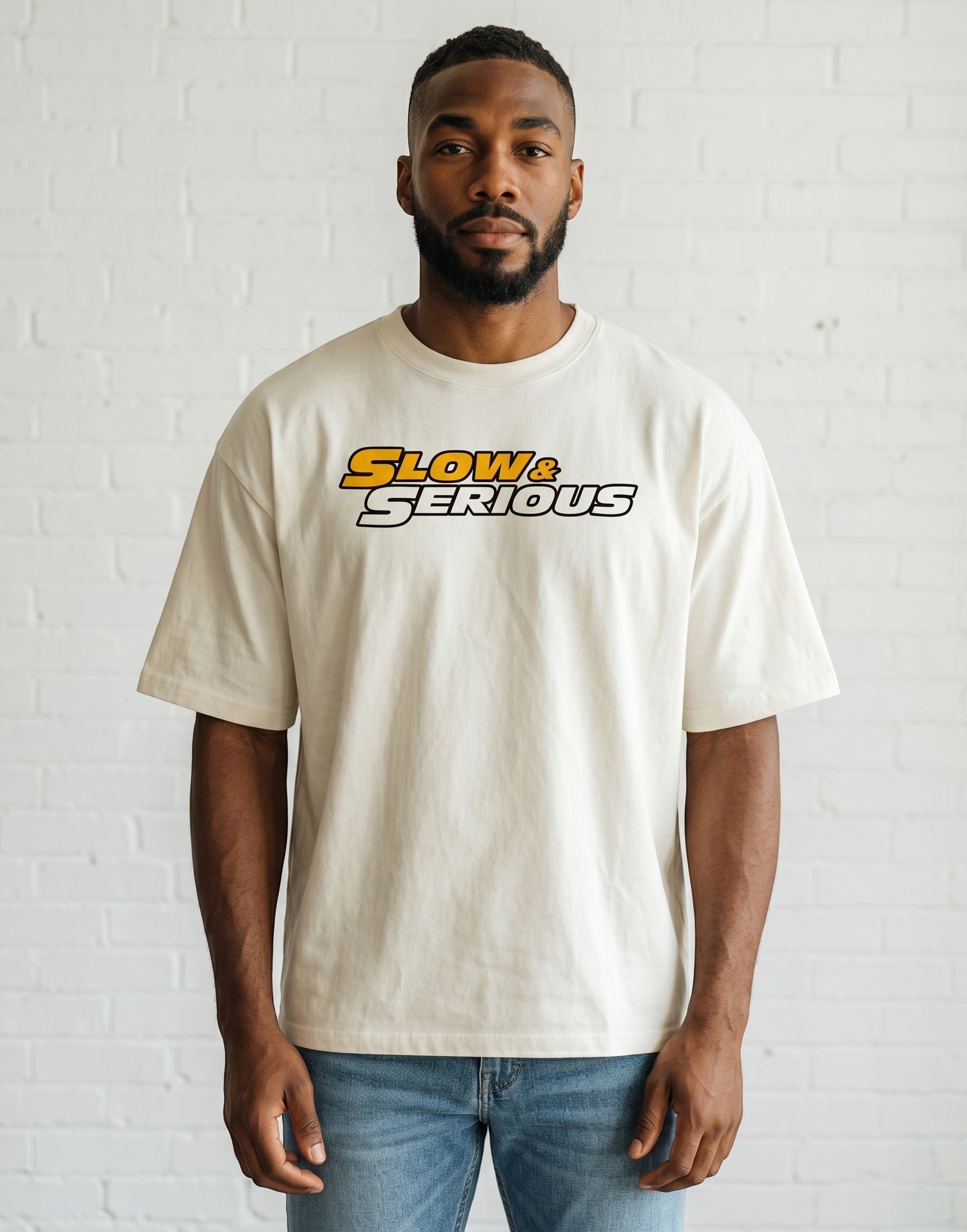 Frolic Saga unisex oversized cream cotton t-shirt with Slow & Serious graphic print worn by a man.