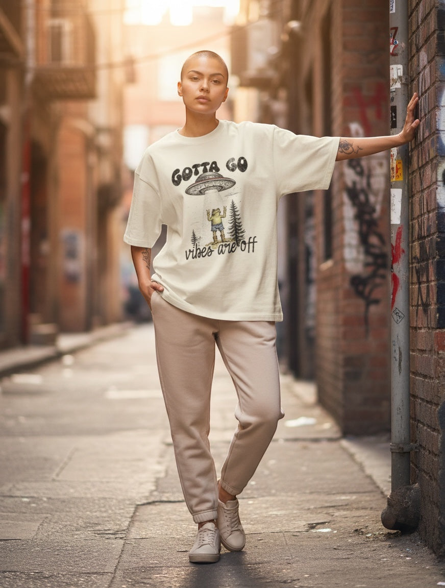 Frolic Saga Unisex oversized classic t-shirt in cream, 100% cotton with a graphic print of an alien abduction.