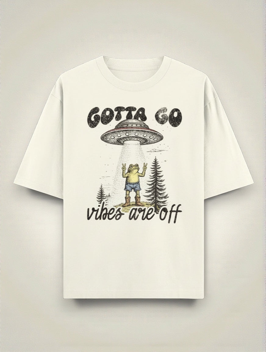 Frolic Saga cream 100% cotton oversized t-shirt with UFO abduction graphic and "Gotta Go Vibes Are Off" text.