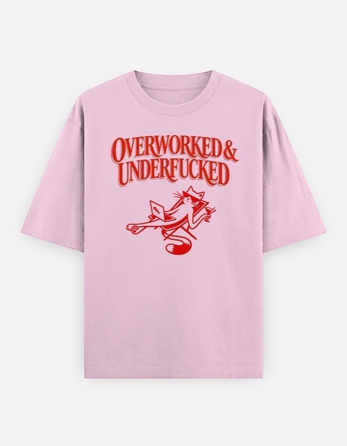 Frolic Saga light pink oversized cotton t-shirt with red graphic text "Overworked & Underfucked" and a cat illustration.