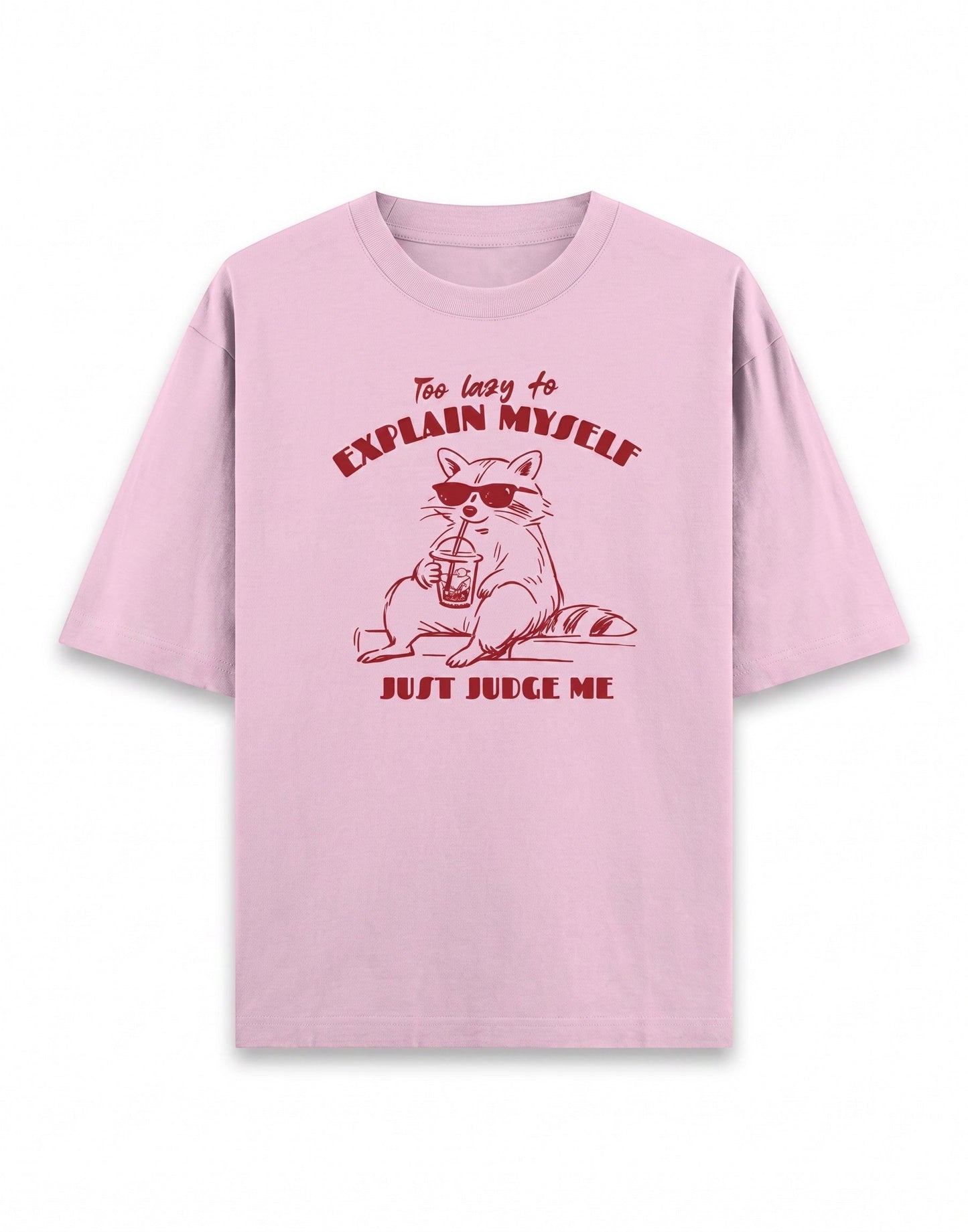 Frolic Saga pink 100% cotton oversized t-shirt with a graphic of a raccoon wearing sunglasses and holding a drink, text reads "Too lazy to explain myself JUST JUDGE ME."