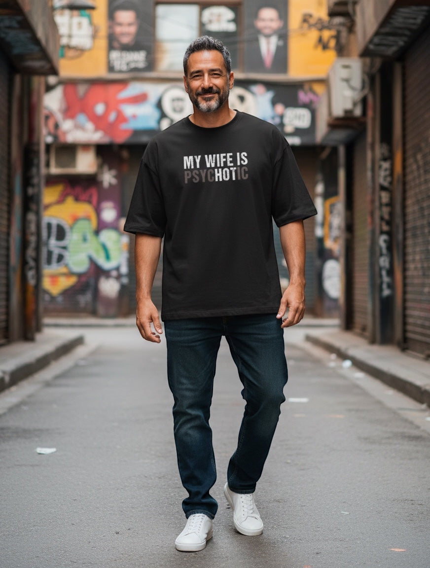 Frolic Saga black 100% cotton oversized graphic tee with "My Wife Is (HOT) Psychotic" illusion text.