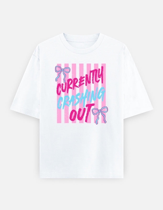 Frolic Saga white 100% cotton oversized t-shirt with pink and blue 'Currently Crashing Out' graphic and pink stripes.