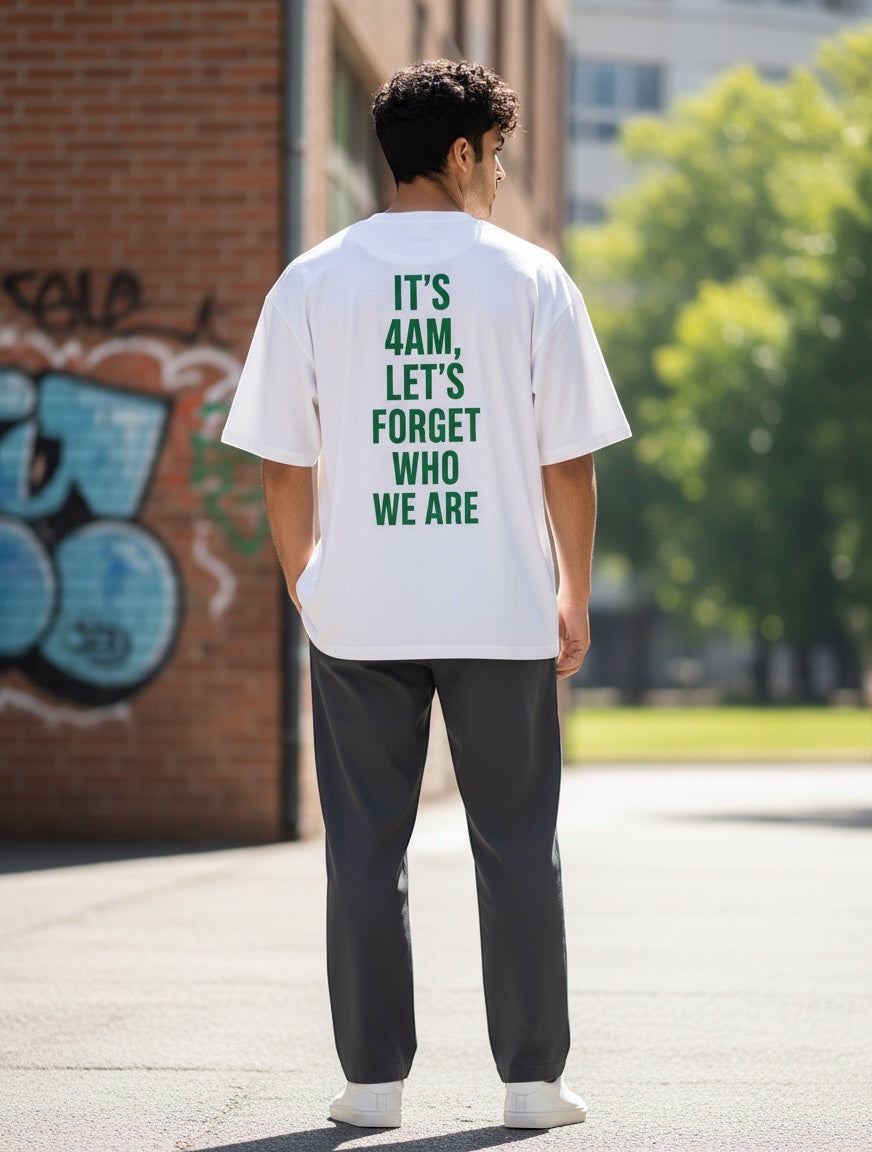 Frolic Saga white 100% cotton oversized t-shirt with green text graphic on back.
